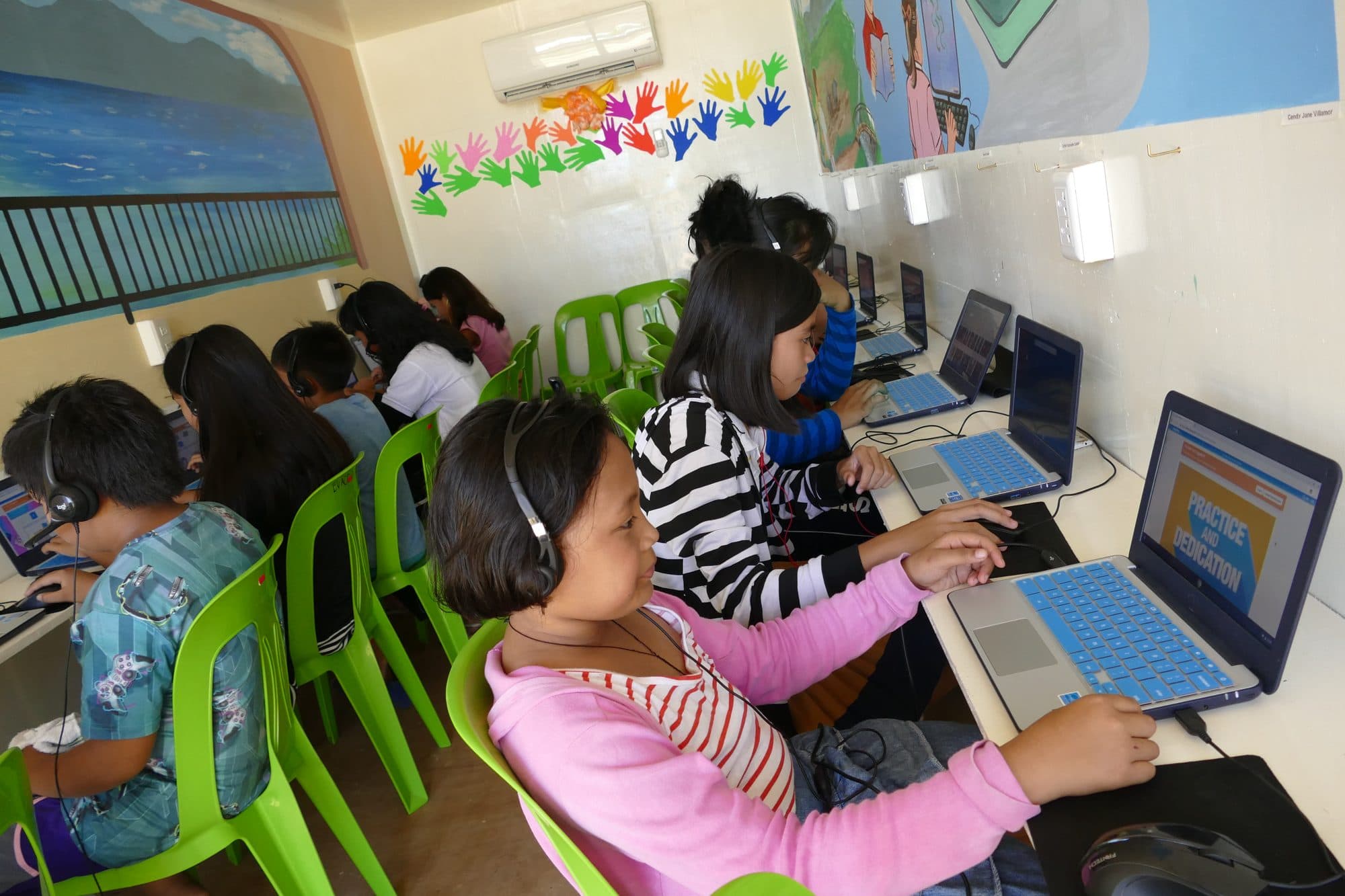 A student at her laptop in the container classroom