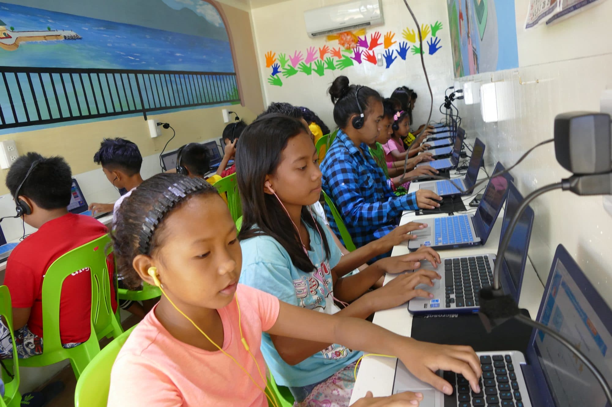 A row of students typing at laptops