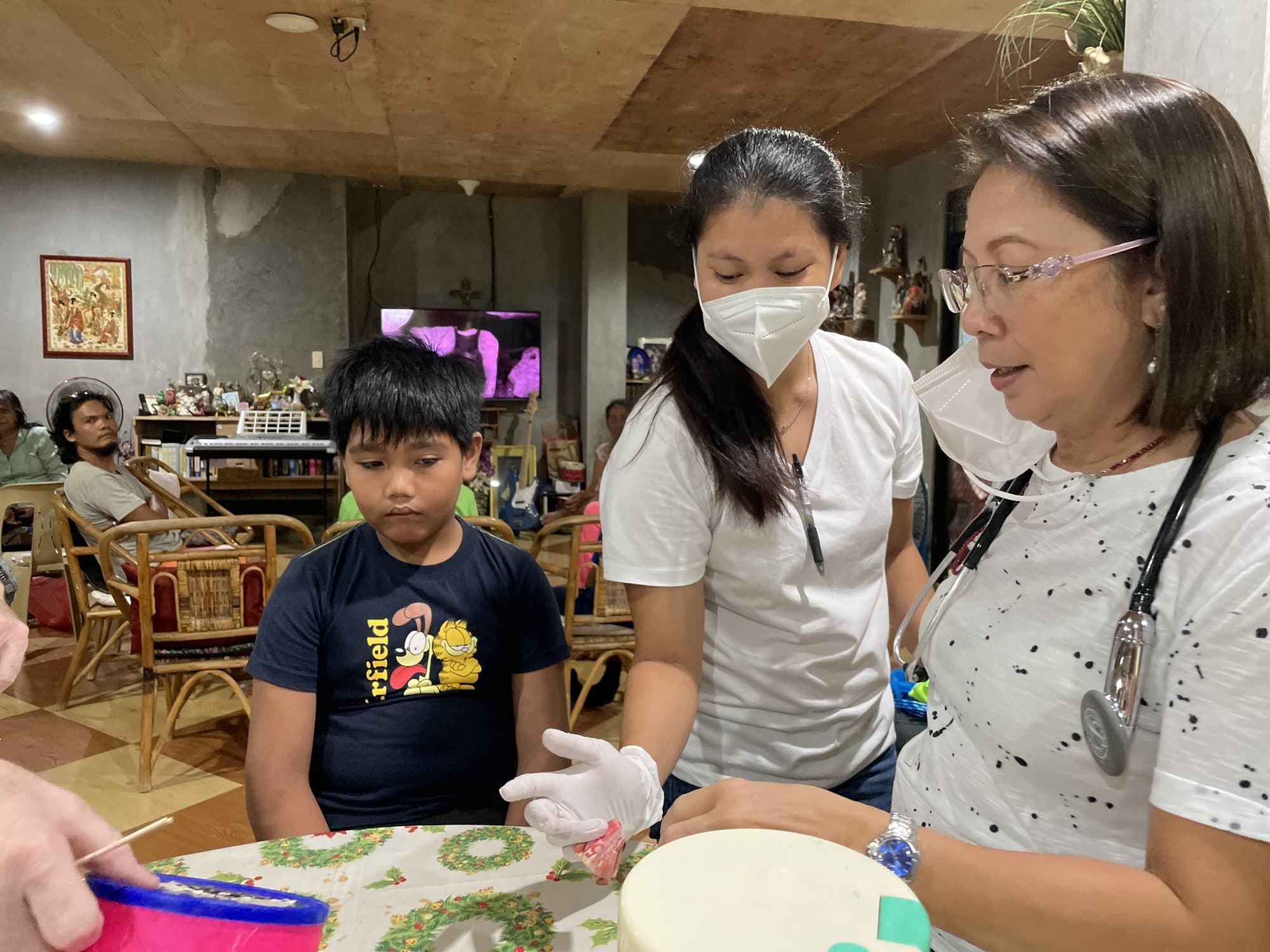 Two clinic nurses examine a boy at the clinic