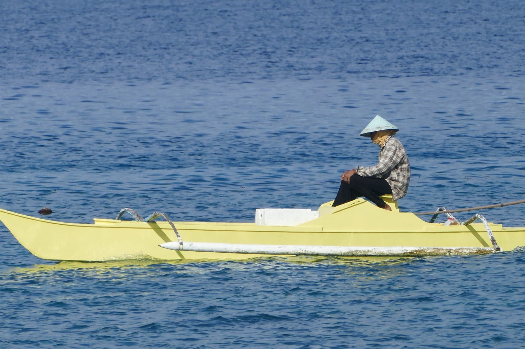 A fisherman in his yellow outrigger