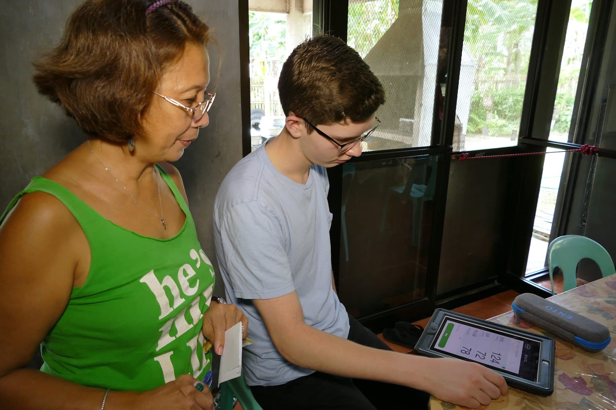 Rhome Nuttall and a volunteer enter a patient's details on a tablet