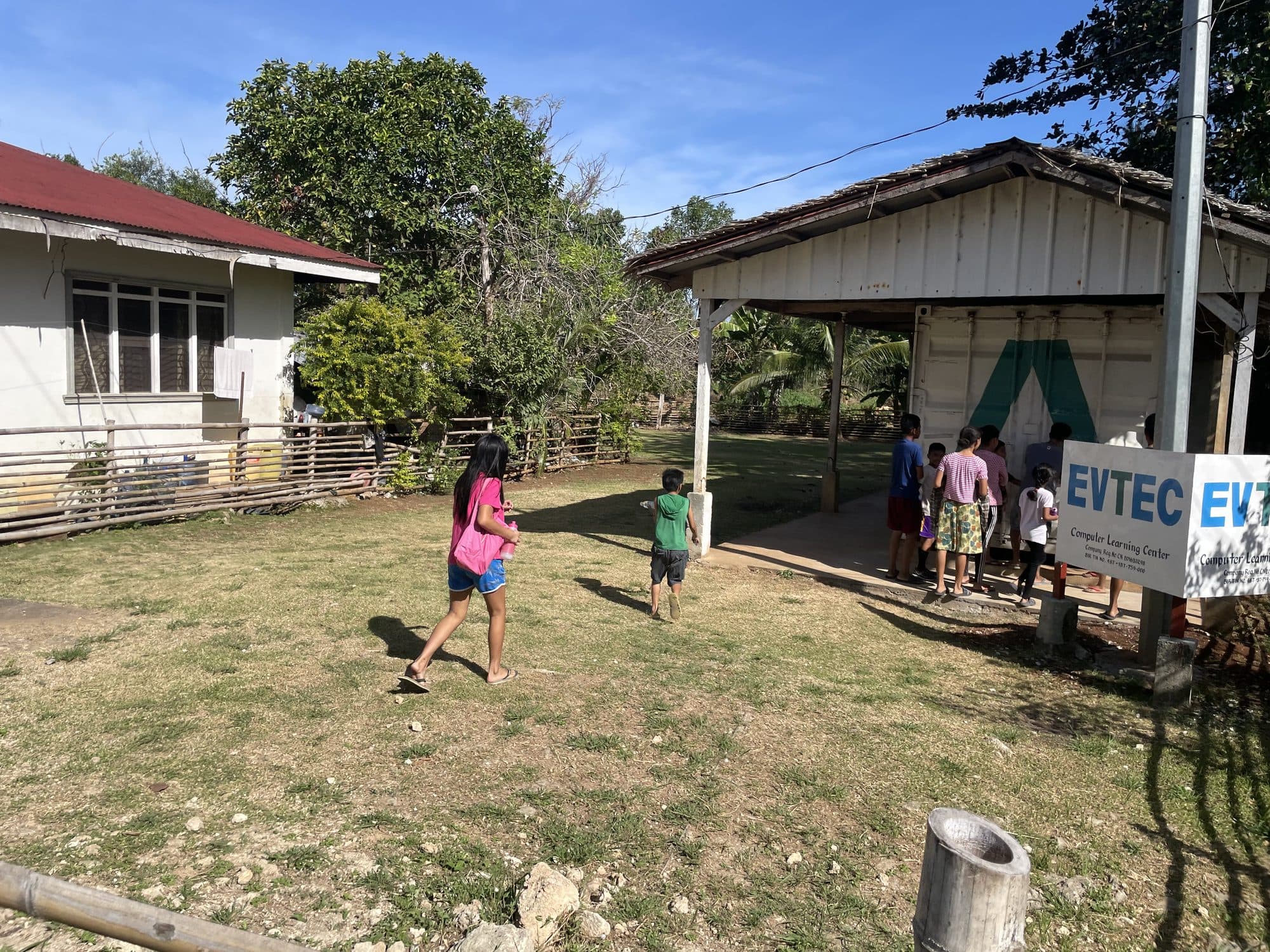 Children running on the grass in front of the learning center